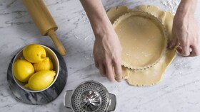Electrolux baker carefully filling the pie tin with the pastry